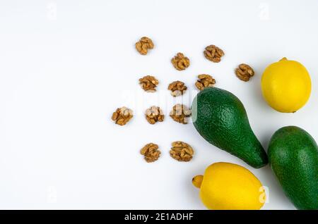 Fresh avocado and lemon and walnuts on a white background. Top view with space to copy. Stock Photo
