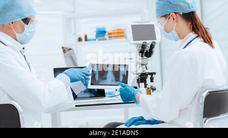 medical colleagues with a digital tablet discussing an x-ray. Stock Photo