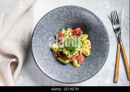 Avocado, tomato and arugula salad. Healthy vegan food. White background. Top view Stock Photo