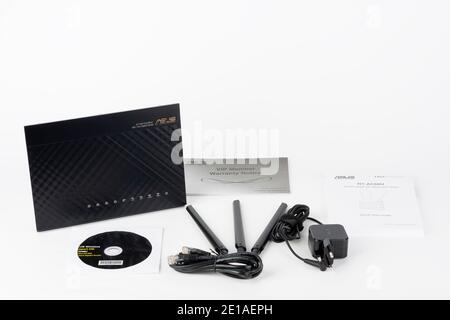 Brnenec, Czech Republic - January 31, 2020: Wifi router Asus RT-AC68U, power cable, quick start guide, three antennas. Asus is a Taiwanese computer an Stock Photo