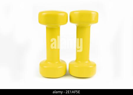 Two yellow dumbbells on white background Stock Photo