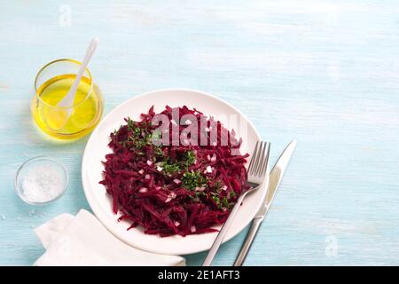 Healthy detox raw beetroot salad with red onion, garlic, herbs and spices on a blue background. diet food. top view, free space Stock Photo