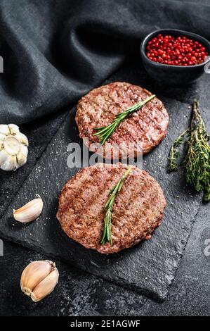 Grilled ground beef patties. BBQ meat. Black background. Top view Stock Photo