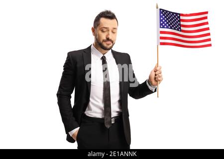 Disappointed businessman holding a USA flag and looking down isolated on white background Stock Photo