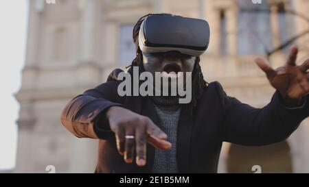Scared african american man with VR headset gesturing like in free fall. High quality photo Stock Photo