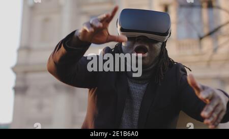 Scared african american man with VR headset gesturing like in free fall. High quality photo Stock Photo