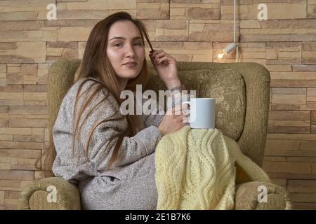 Resting girl in a chair with a cup of tea Stock Photo