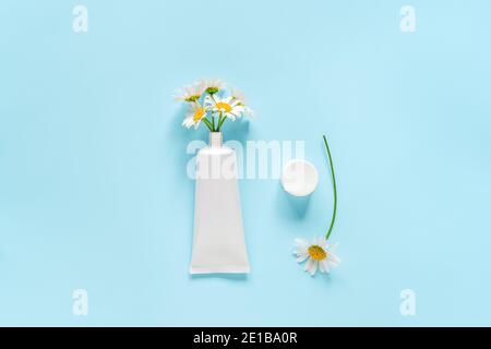 Bouquet of chamomile flowers from cosmetic, medical white tube for cream, ointment, toothpaste or other product. Concept natural herbal organic cosmet Stock Photo