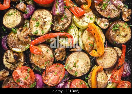 Roasted vegetables mix on baking tray. Top view. Close up Stock Photo