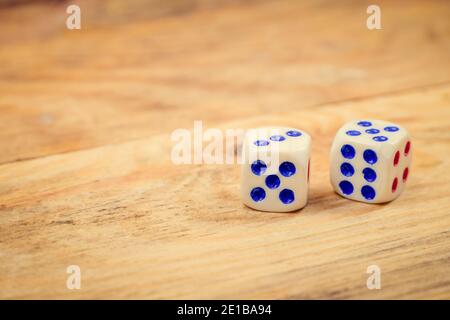 Dice with blue and red dots on wooden background with copy space Stock Photo