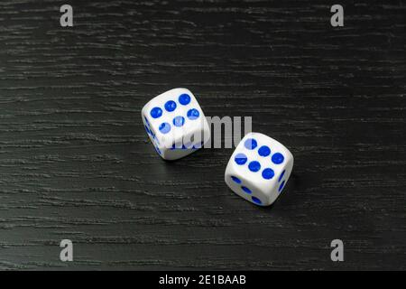 Dice with blue and red dots on black background with copy space Stock Photo