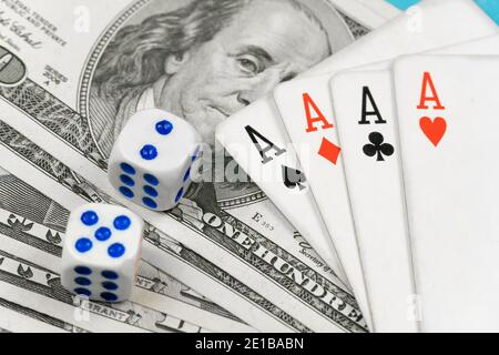 Dice, four aces lying on dollar bills close-up. Concept of playing poker Stock Photo