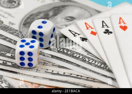 Dice, four aces lying on dollar bills close-up. Concept of playing poker Stock Photo