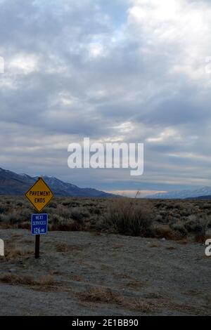 road sign for unpaved road and next service in the fish lake valley near Big Pine California, Waucoba Road to the Death Valley Stock Photo