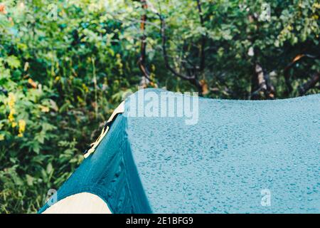 Dew drops on green tourist tent. Waterproof fabric rain, test of bad weather Stock Photo