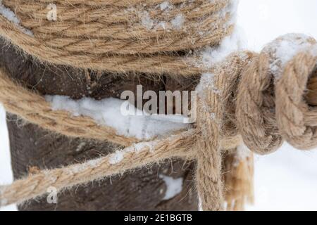 Logs are tied with rough hemp rope. Sea node for building house. Stock Photo