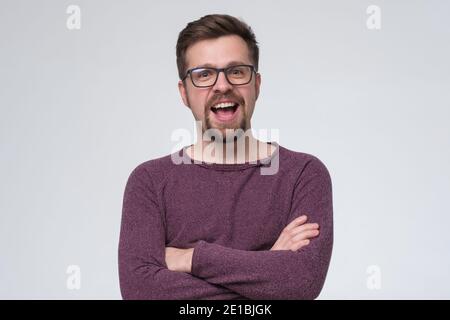 Smiling young man with beard and glasses looking at camera. Studio shot. Stock Photo
