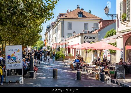 People enjoying sidewalk cafes in the market square in the small town of Carouge bordering Geneva. Stock Photo