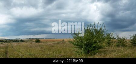 Summer rural landscape with dark stormy clouds over the farm fields Stock Photo