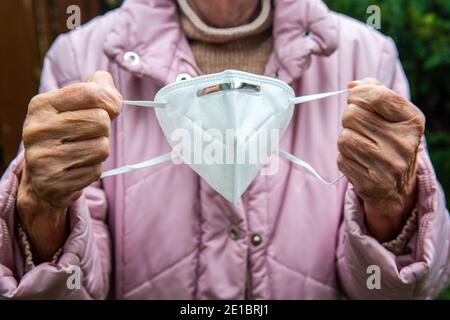 close-up of older womans hands holding face mask Stock Photo