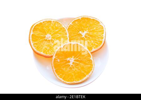 Plate with three slices of dried orange isolated on white background. Stock Photo