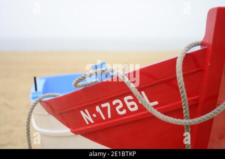 Small fishing red boat on the Nazaré beach, Portugal Stock Photo