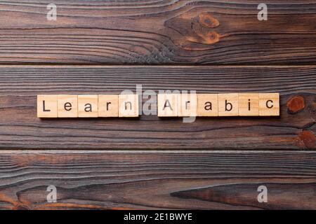 learn arabic word written on wood block. learn arabic text on table, concept. Stock Photo