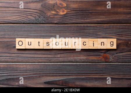 outsourcing word written on wood block. outsourcing text on table, concept. Stock Photo