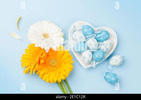 Easter greeting card with gerbera flowers and colorful easter eggs. Top view flat lay Stock Photo