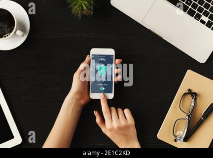 Woman holding and using smartphone with vpn app Stock Photo