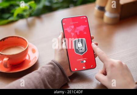 Woman holding and using smartphone with vpn app Stock Photo