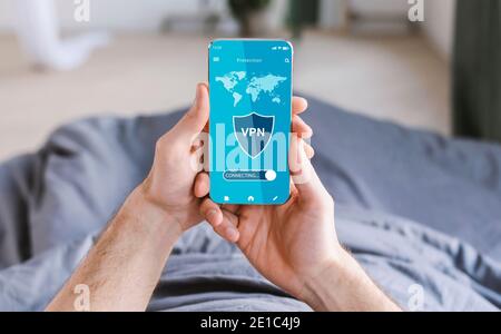 Young man holding and using cellphone with vpn app Stock Photo