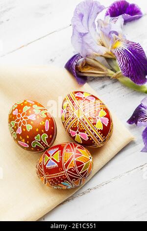 Three handmade Easter eggs decorated with wax-resist dyeing technique. Ukrainian pysanky on the table. Vertical composition Stock Photo