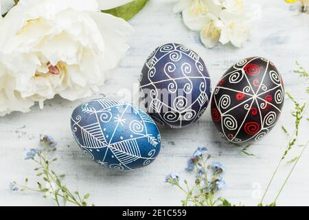 Three pysanky handmade Easter eggs. Ukrainian pysanky decorated with wax-resist dyeing technique. Holiday postcard Stock Photo