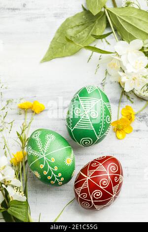 Three pysanky handmade Easter eggs. Ukrainian pysanky decorated with wax-resist dyeing technique. Holiday postcard Stock Photo