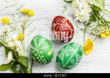 Three pysanky handmade Easter eggs. Ukrainian pysanky decorated with wax-resist dyeing technique. Holiday postcard Stock Photo