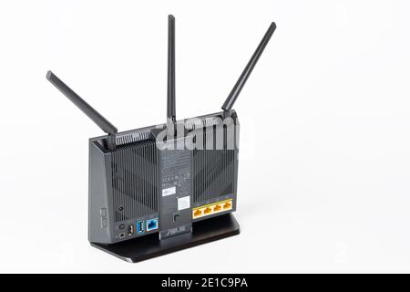 Brnenec, Czech Republic - January 31, 2020:Rear view of  Wi-Fi router Asus RT-AC68U with  three antennas. Asus is a Taiwanese computer and electronics Stock Photo