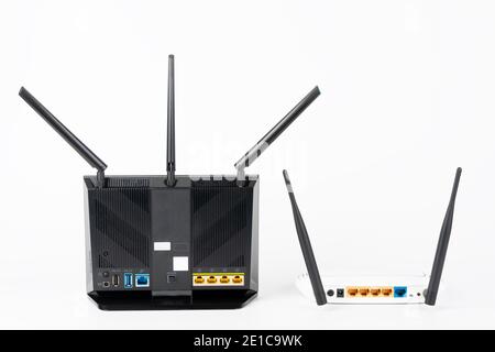 Rear view of  two Wi-Fi  routers, wireless devices with two  and three antennas.  Black router has  five Gigabit Ethernet ports, ultrafast USB 3.1 por Stock Photo
