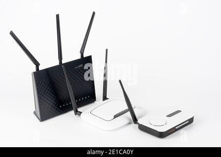 Three  Wi-Fi  routers, wireless devices with one, two and three antennas.  Black router has five Gigabit Ethernet ports, ultrafast USB 3.1 port and  U Stock Photo