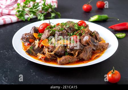 Roast offal with vegetables. Armenian dish Kuchmachi. Stock Photo