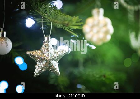 Christmas tree decoration by silver star and blurred christmas lights Stock Photo