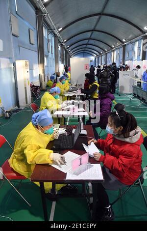 (210106) -- BEIJING, Jan. 6, 2021 (Xinhua) -- People register for their COVID-19 vaccinations at a temporary vaccination site in Haidian District of Beijing, capital of China, Jan. 6, 2021. (Xinhua/Ren Chao) Stock Photo