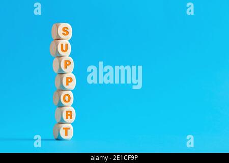 The word support on tiered wooden cubes on blue background. Stock Photo