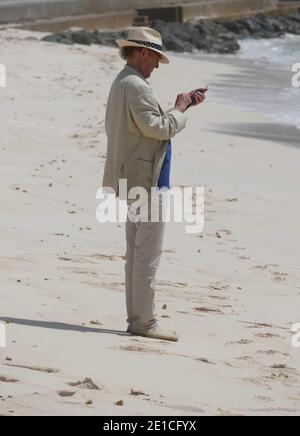 Man using his phone on the beach Stock Photo