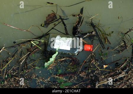 Empty Vodka bottle floatng in flood water.  March.  West Sussex Coastal Plain, Chichester Plain. Stock Photo