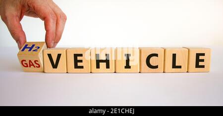 Gas or H2 hydrogen vehicle symbol. Male hand turns a cube and changes words 'gas vehicle' to 'H2 vehicle'. Beautiful white background, copy space. Bus Stock Photo