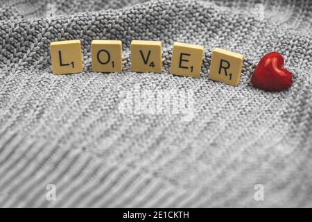 Valentine's Day concept with word lover, red heart on a knitted sweater background Stock Photo