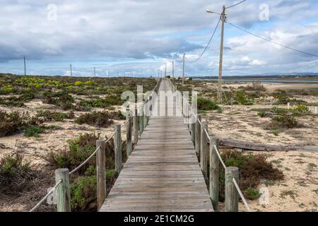 An endless long wooden boardwlk in the Ria Formosa National Park on the Algarve Stock Photo