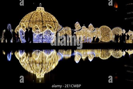 06 January 2021, Saxony-Anhalt, Magdeburg: Visitors walk through the installation 'Lichterwelten' on the Domplatz. The current Corona restrictions in Saxony-Anhalt are valid until the weekend. For the time after that, the state government must issue a new ordinance after the nationwide planned extension of the lockdown until the end of January. Photo: Ronny Hartmann/dpa-Zentralbild/dpa