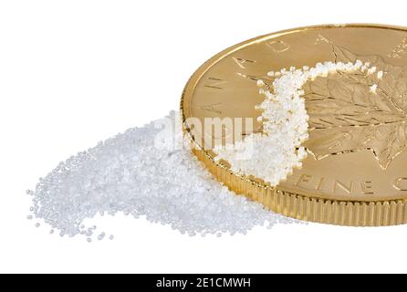 White sand scattered on gold Canadian coin photographed on a white background Stock Photo